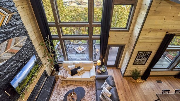 Ein geräumiges Zimmer mit großem Fenster und Blick auf eine Terrasse und die umliegende Landschaft.