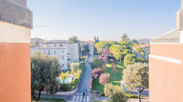 A residential street with houses, trees, and a pedestrian crossing.
