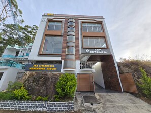 Un edificio moderno con un letrero que indica SKR Sivabhagya Adventure Resort.