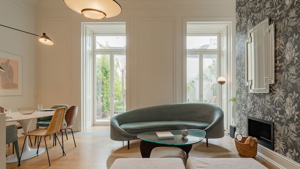 Una sala de estar moderna con un sofá verde, una mesa de centro de vidrio y una chimenea.