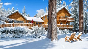 Ein Hotel im Blockhausstil mit zwei Hauptgebäuden, Holzbalkonen und verschneiter Umgebung.