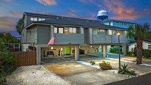 A modern two-story building with a flat roof, a water tank on the roof, and a covered parking area. - 2 Blocks from the Beach: The Coquina Cottage (Jacksonville Beach)