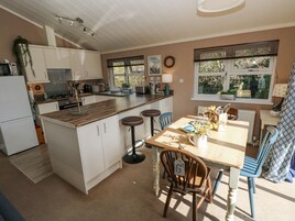 A kitchen with white cabinets, a wooden countertop, and a dining area with a table and chairs.