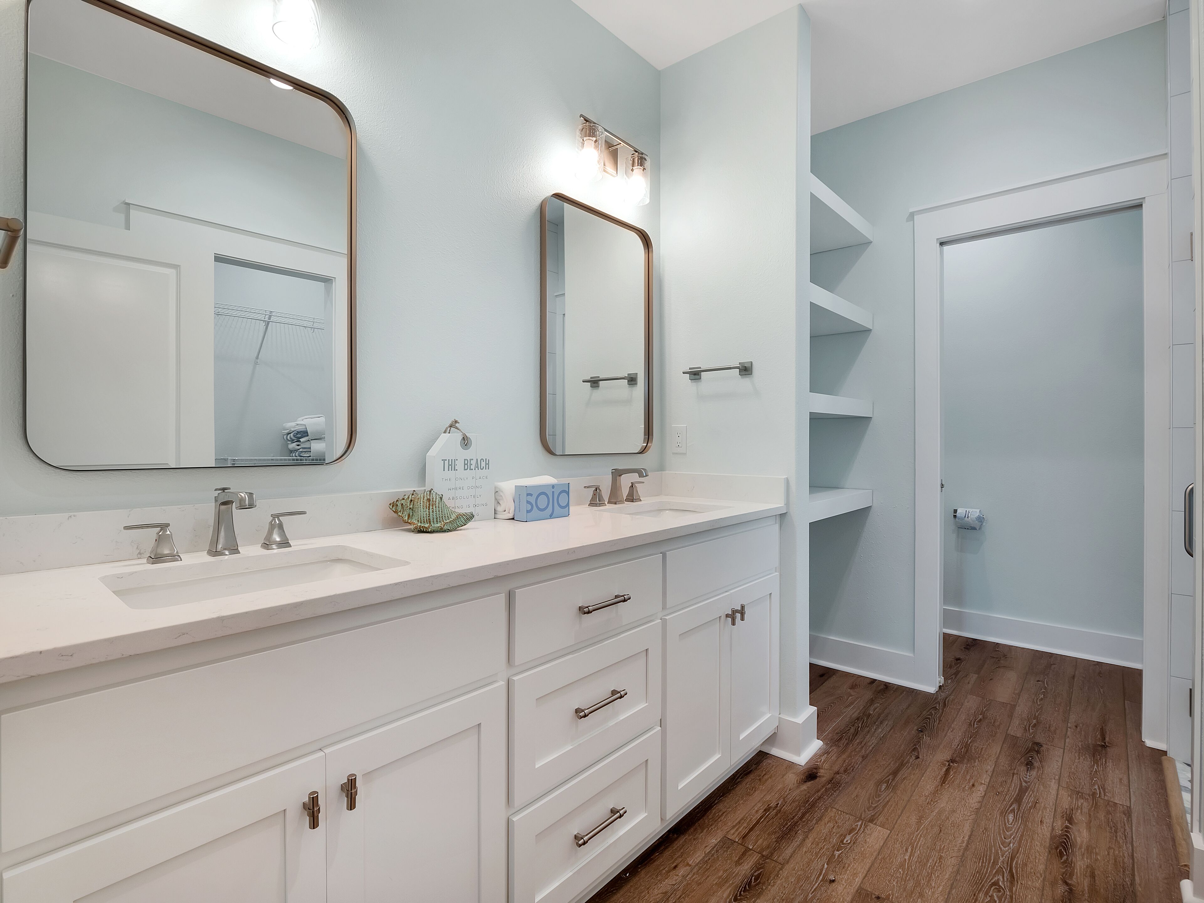 Un bagno con un mobile lavabo bianco, due lavandini, uno specchio grande e un porta asciugamani.