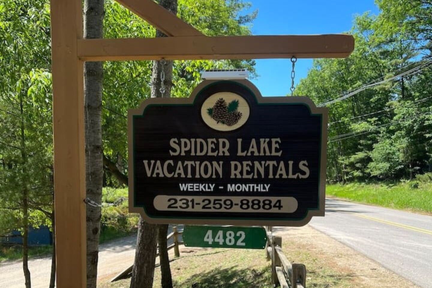 A sign for Spider Lake Vacation Rentals advertising weekly to monthly rentals with a contact number.