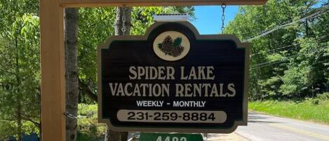 A sign for Spider Lake Vacation Rentals advertising weekly to monthly rentals with a contact number.