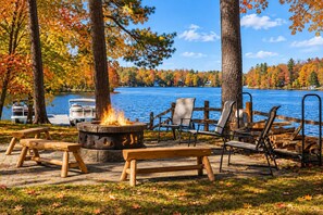 A lakeside campsite with a fire pit, benches, and chairs. - Sauna l Balcony l Bonfires l Sandy Beach l Fishing (Traverse City)