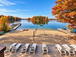 Une plage au bord du lac, avec des chaises longues, des kayaks et un quai.