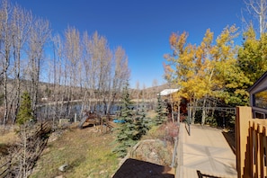 A view of a backyard with a wooden deck, a swing set, and a small pond. - Private lake front home, Open layout, Remodeled kitchen, Excellent views 334 (Silverthorne)