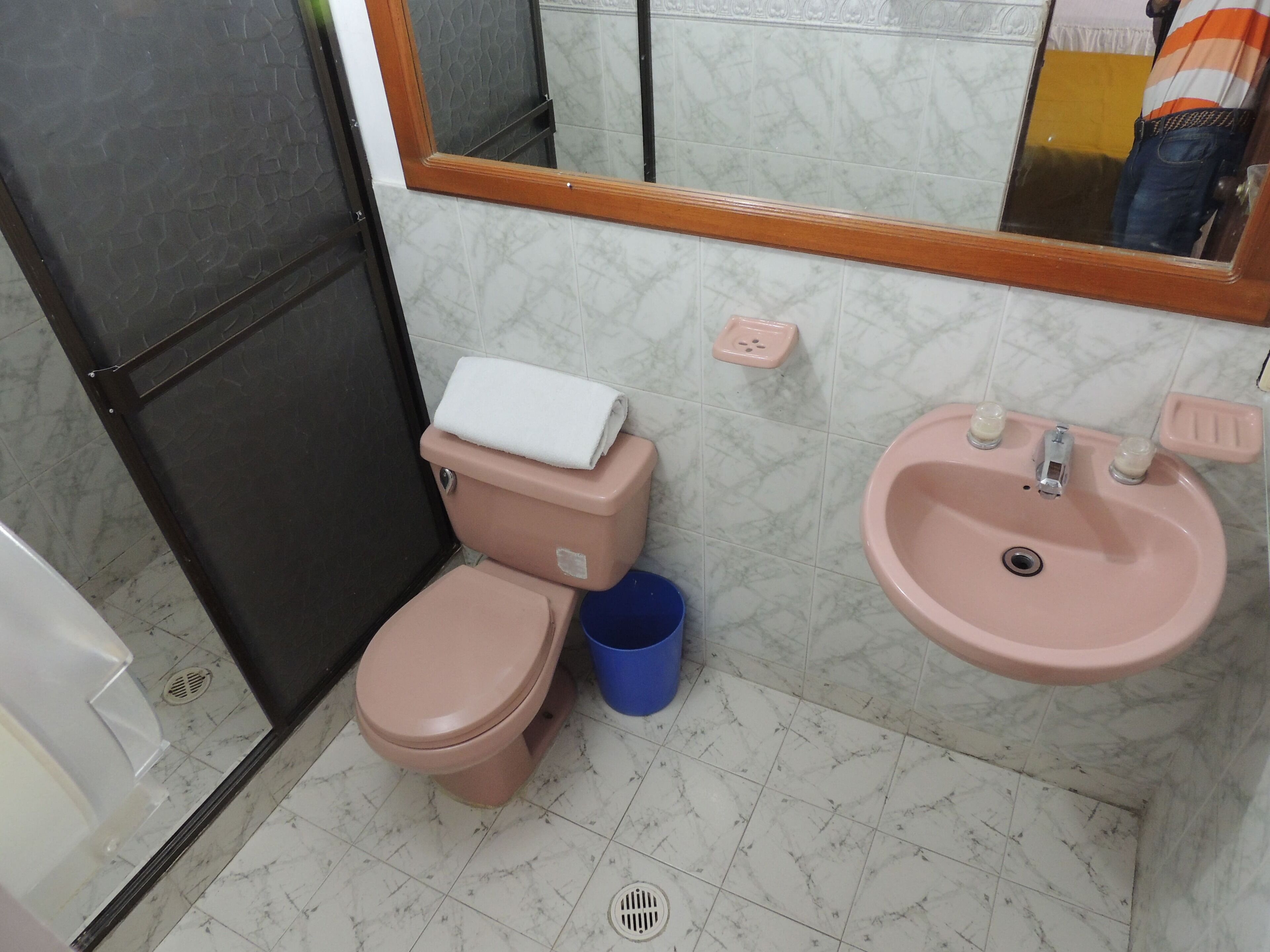 Un baño con inodoro, lavamanos y espejo.