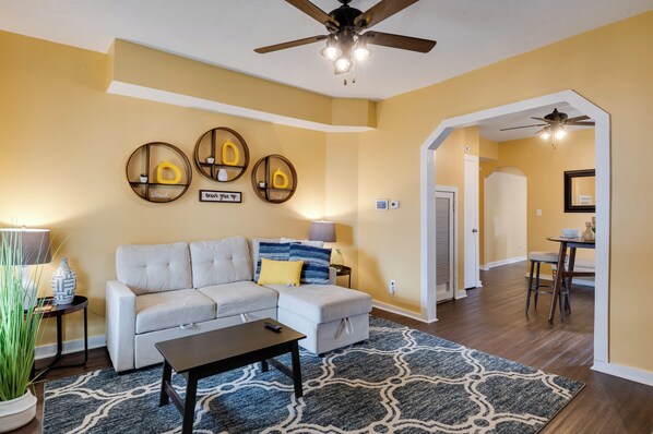 A living room with a sofa, coffee table, and decorative wall art. - Chic Indianapolis Home w/ Yard Near Downtown! (Indianapolis)