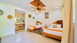 A hotel room with two beds, a ceiling fan, a bathroom with a mirror, and a small plant. - Olinca Boutique Hotel (Cahuita)