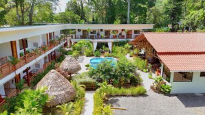 A resort with a pool, thatched-roof structures, and lush greenery. - Olinca Boutique Hotel (Cahuita)
