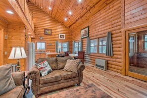 Cozy cabin interior with a living area, dining space, and kitchen, perfect for meals and relaxation.