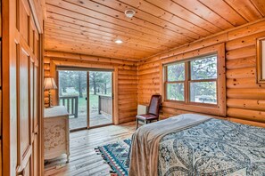 Cozy retreat with a large bed, desk, and glass door offering a view of the outdoors.