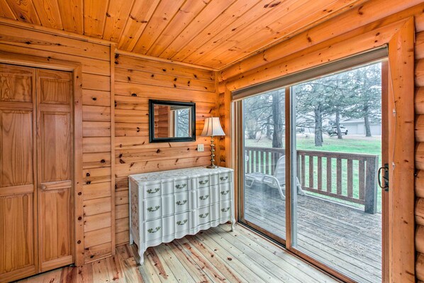 Enjoy a room with a sliding glass door leading to a deck overlooking a serene landscape.