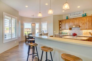 A spacious kitchen with a large island, wooden bar stools, and pendant lighting. - Private Pool! Oasis-Like Group Getaway in Phoenix (Phoenix)