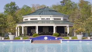 A two-story building with a covered patio and a swimming pool in front. - Tennis, Pools, Games. Huge 4BDR Powhatan Resort Villa. FIreplace. King Suites. (Williamsburg)