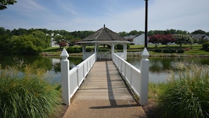 Stroll across the bridge to a serene gazebo surrounded by lush greenery and well-manicured lawns.