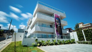 Un hotel moderno con estructura de dos pisos, un llamativo letrero 'Liv' y un jardín bien cuidado.