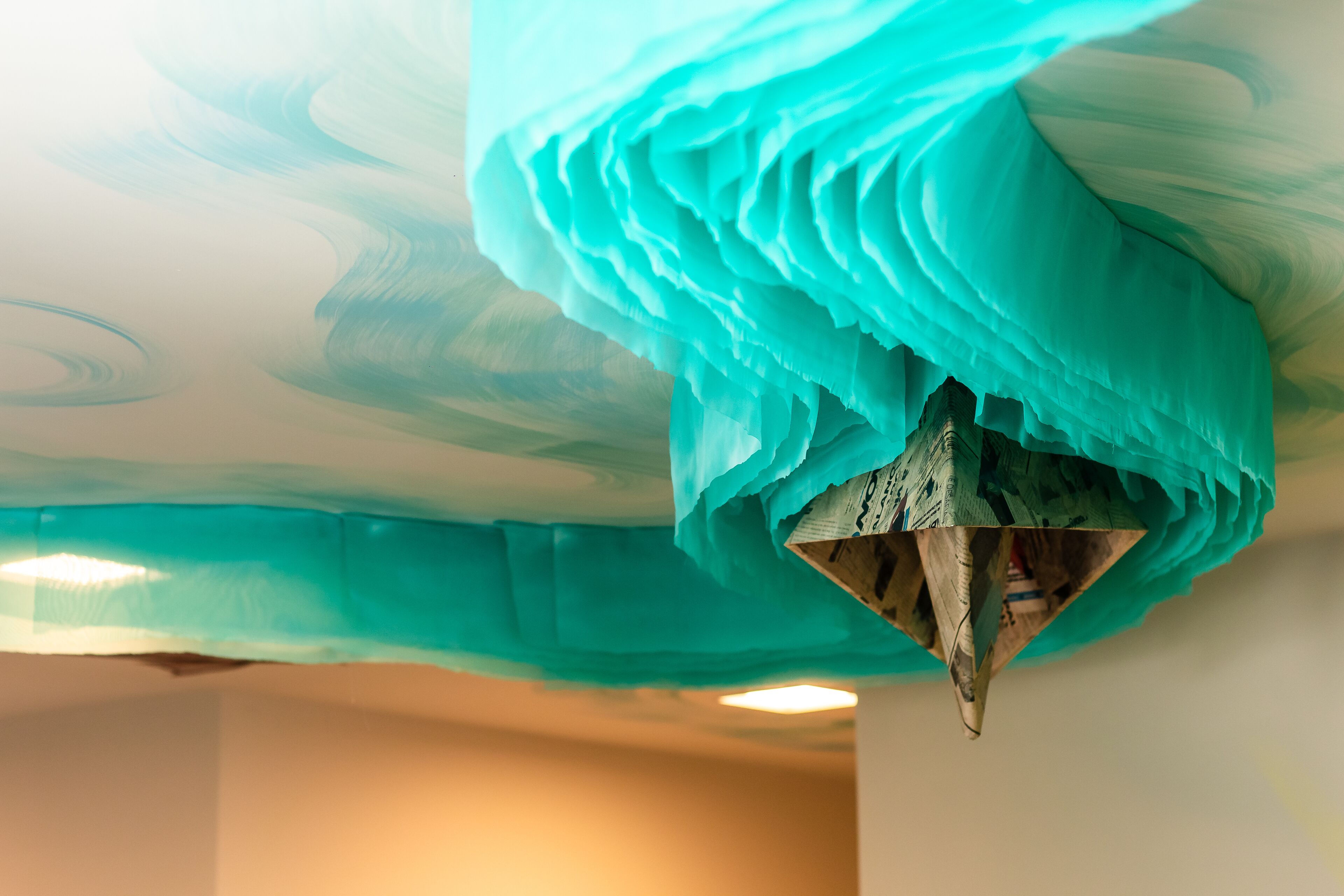 A ceiling with a textured, wave-like design in a teal color.