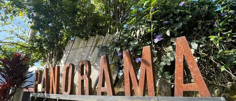 A sign with the word 'PONORAMA' in large letters, surrounded by greenery and plants.