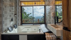 Een badkamer met een groot raam, een bad en een douche.