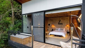 Een moderne slaapkamer met een bed, nachtkastje en een hangstoel.