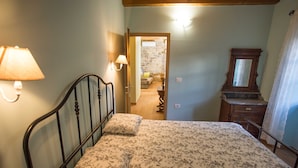 A bedroom with a bed, a nightstand, a lamp, a dresser, and a mirror. - Apartment Baladur (Koper)