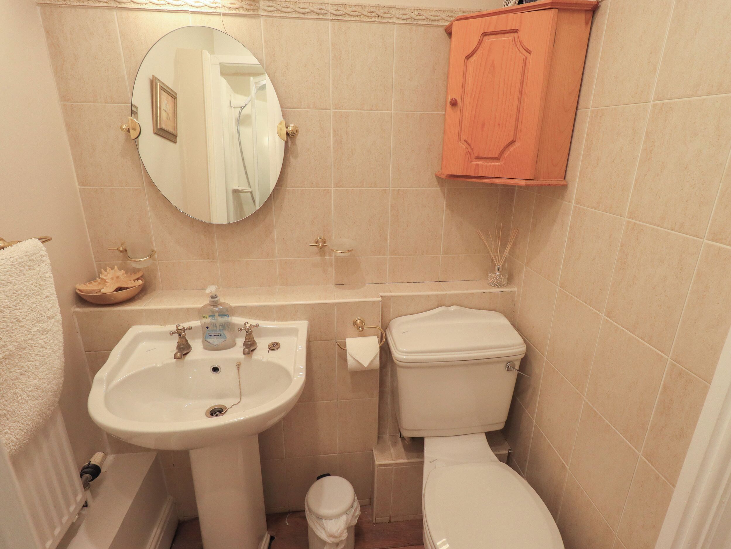 Une salle de bain avec un lavabo, des toilettes et un miroir.