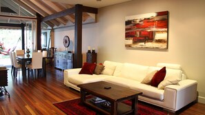 Una sala de estar moderna con un sofá blanco, una mesa de centro y un cuadro en la pared.