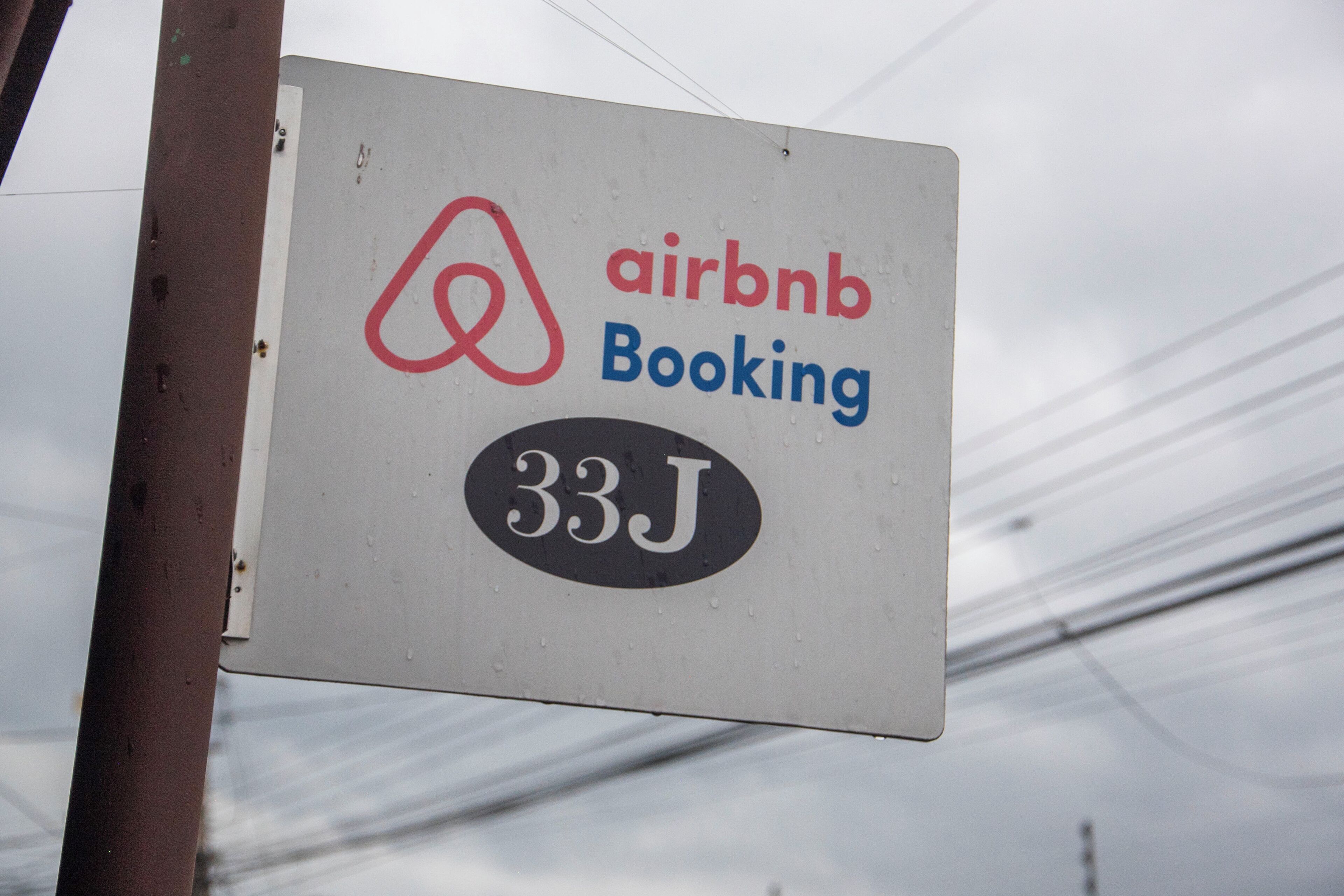 Een bord met het Airbnb-logo en de tekst 'airbnb Booking 33J'.