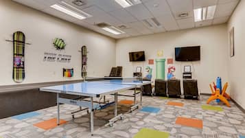 Una habitación con dos mesas de ping pong y dos consolas Nintendo Switch.