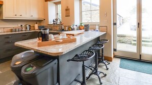 Una cucina moderna con una grande isola, sgabelli da bar e vista all'esterno.