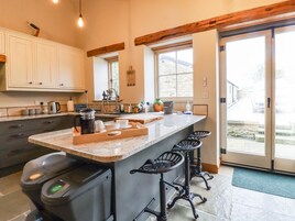 Una cocina moderna con una isla grande, taburetes de bar y vistas al exterior.