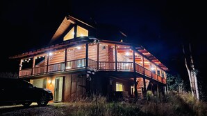 Une cabane en rondins dotée d’un balcon et d’un escalier menant à l’étage supérieur.