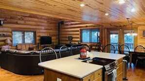 L’intérieur d’une cabane en rondins comprend un espace de vie, une cuisine et un coin repas.