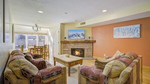 Ein gemütliches Wohnzimmer mit Kamin, gestreiften Sofas und einem Essbereich.