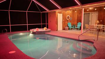 Relax by the pool in a, enclosed space with a hot tub and seating area.