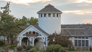 Ein Gebäude mit der Aufschrift "The Shoppe at Big Cedar", mit einer Stein-Fassade, einem Turm mit Fenstern und einem Garten.