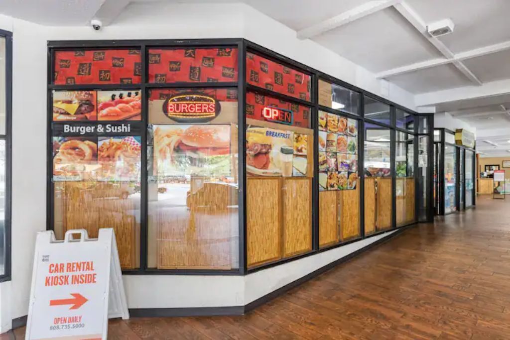 A restaurant with a sign indicating a car rental kiosk inside.