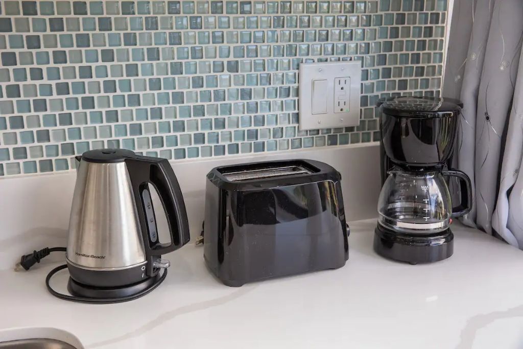 Un plan de travail de cuisine avec une machine à café, un grille-pain et une bouilloire.