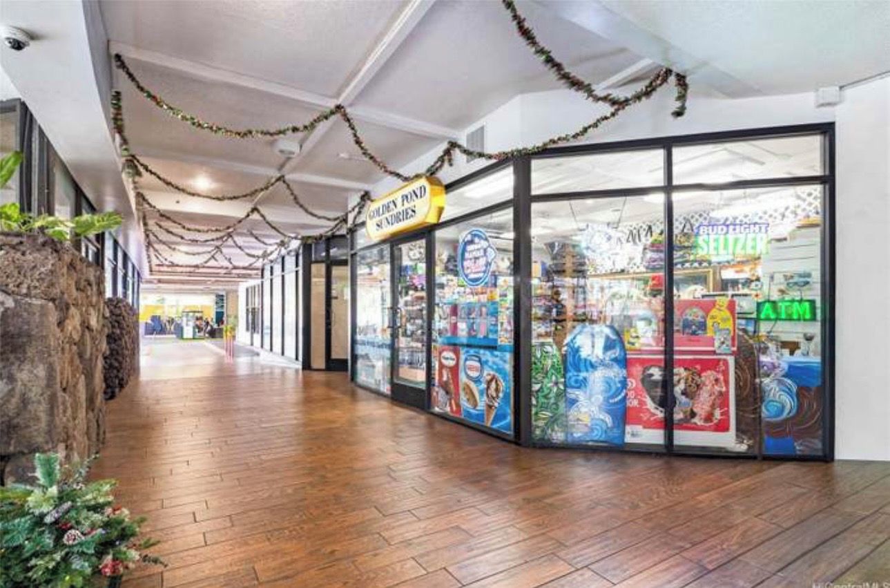 A corridor with a wooden floor, a store with glass doors, and a sign for 'Golden Pond Sundries'.