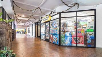 A corridor with a wooden floor, a store with glass doors, and a sign for 'Golden Pond Sundries'.