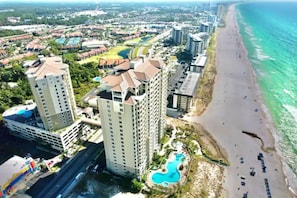 Un hôtel situé sur la côte, composé de plusieurs immeubles de grande hauteur, et doté d’une plage et d’une piscine.