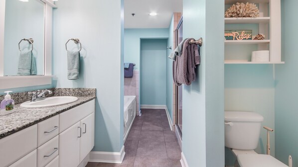 Une salle de bain équipée d’un lavabo, d’un miroir, d’un porte-serviettes et de toilettes.