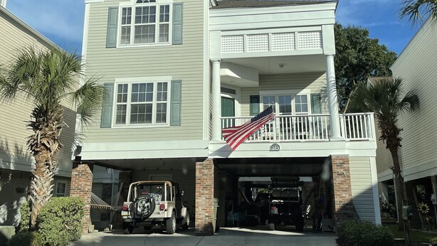 A two-story house with a garage, a balcony, and an American flag. - Small Efficiency near Surfside Beach Pier (Surfside Beach)