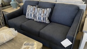 A grey armchair with a patterned pillow and a tag indicating a sale price. - Small Efficiency near Surfside Beach Pier (Surfside Beach)
