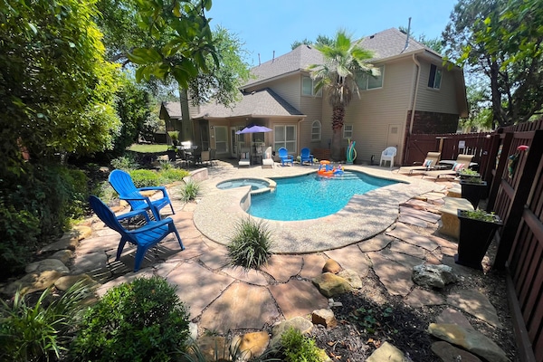 Enjoy relaxing in our tranquil backyard pool with lush landscaping and hot tub.