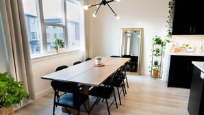 Una cocina moderna con una mesa de madera, sillas negras y plantas en macetas.